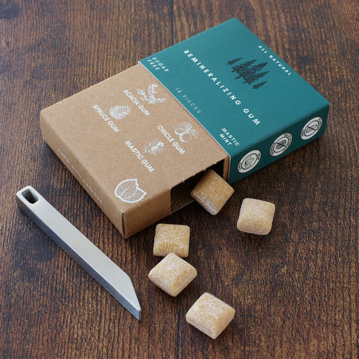 eknest gum cubes spilling from box with the Minimalist Multi-tool Key-chain on wooden surface